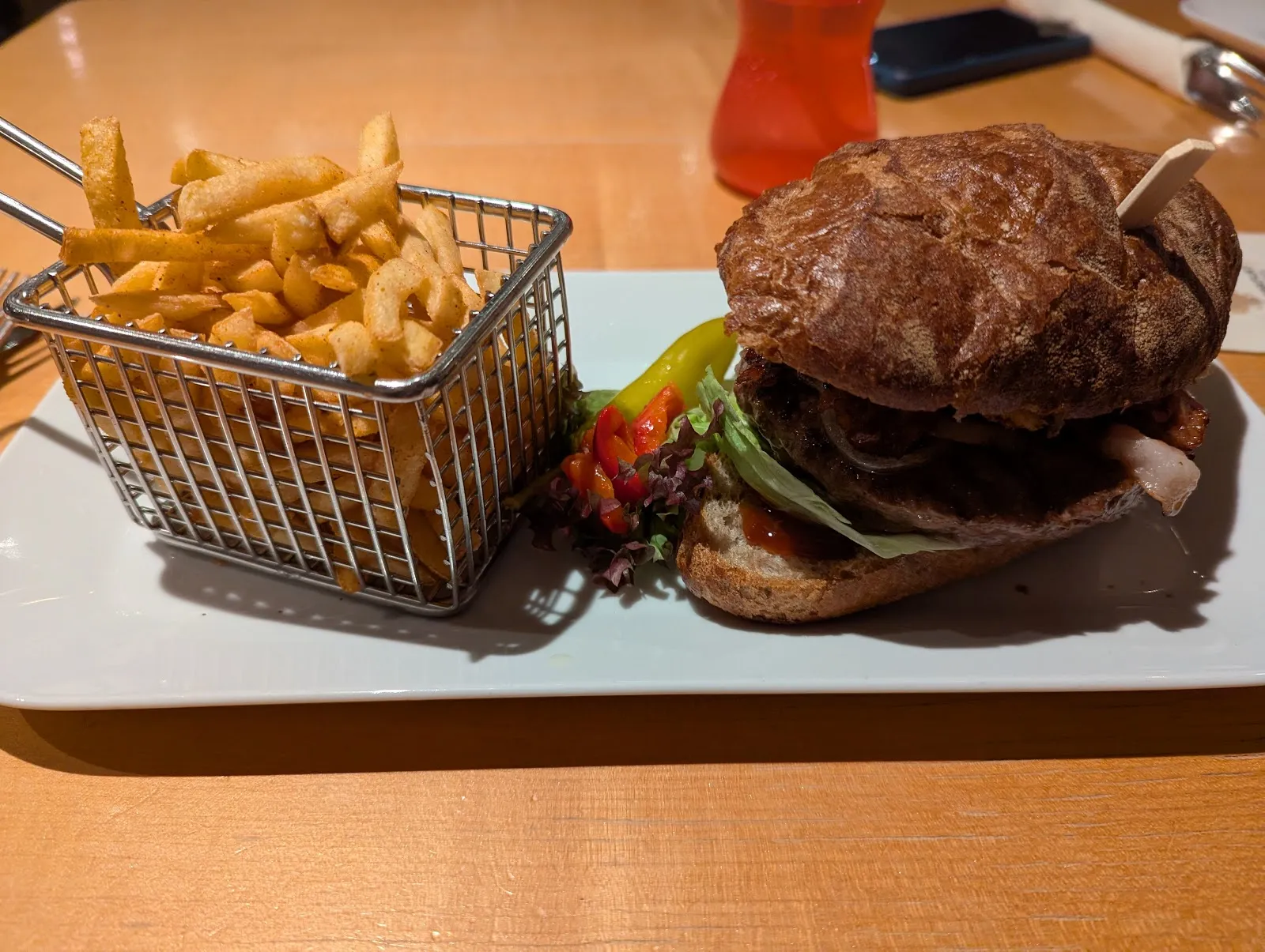 Burger mit einem Körbchen Pommes im Bistro Flip